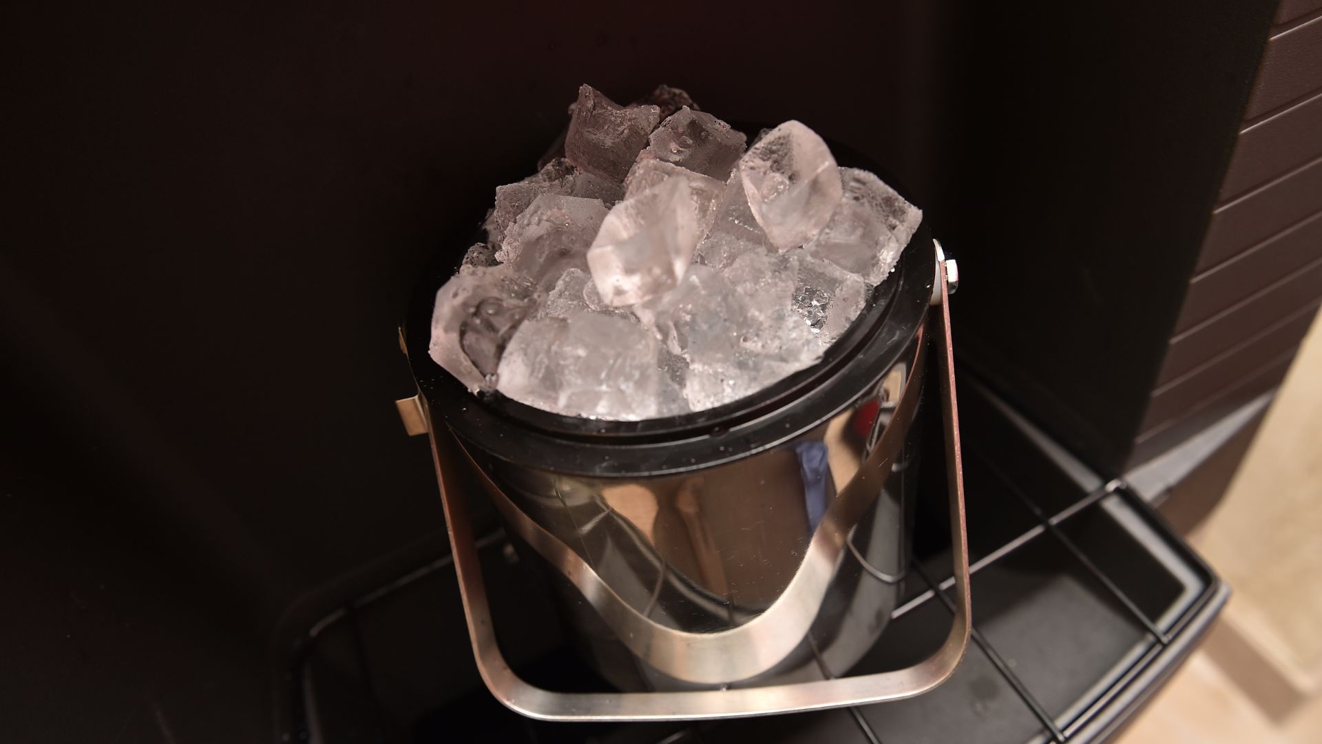 A metal bucket filled with ice on top of a stove